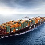 ship2 augenaufblog Large cargo container ship on open sea loaded with stacked orange and green containers hull letters visible UASC
