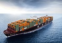 Large cargo container ship on open sea loaded with stacked orange and green containers hull letters visible UASC